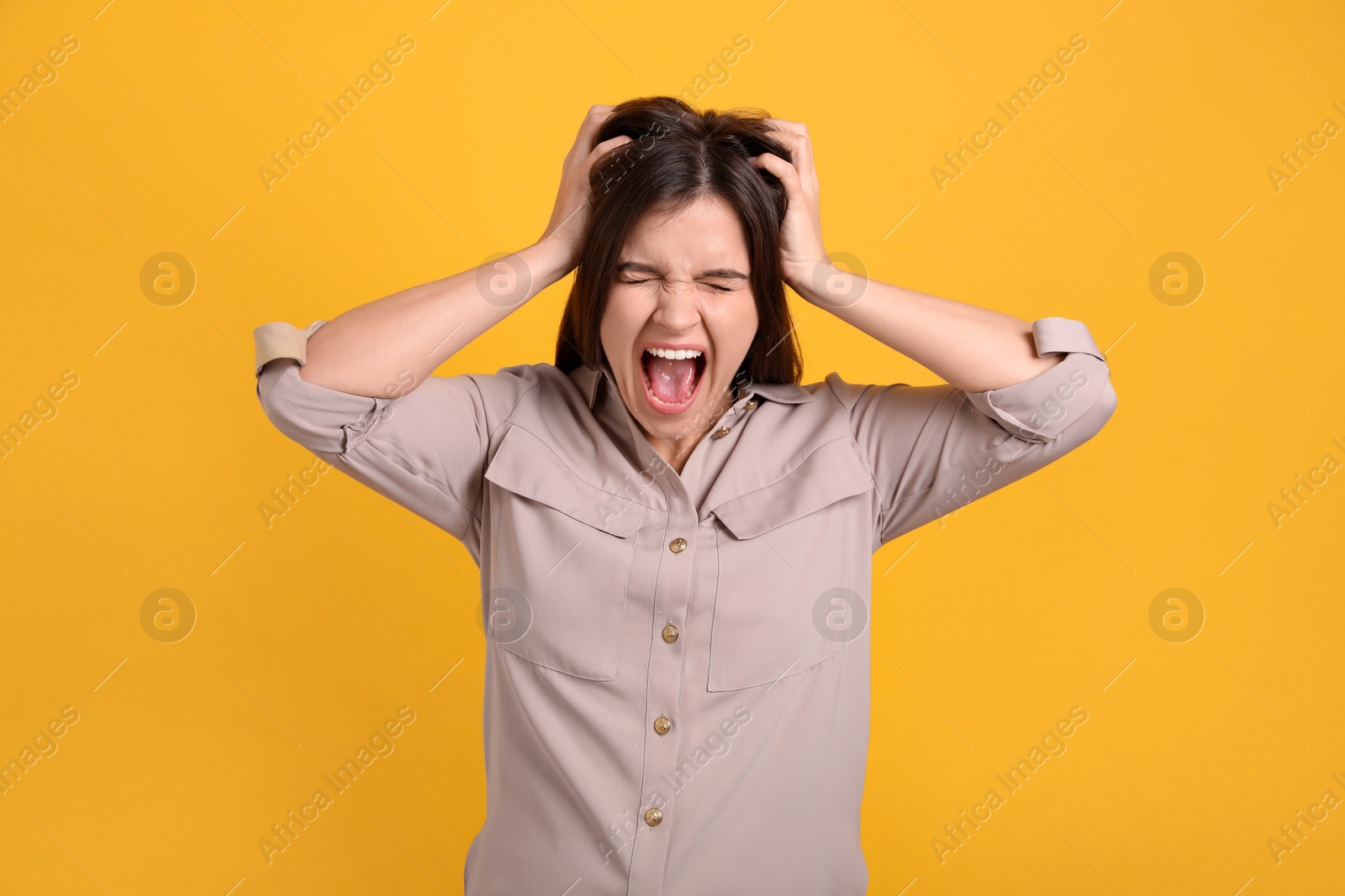 Photo of Portrait of stressed young woman on yellow background