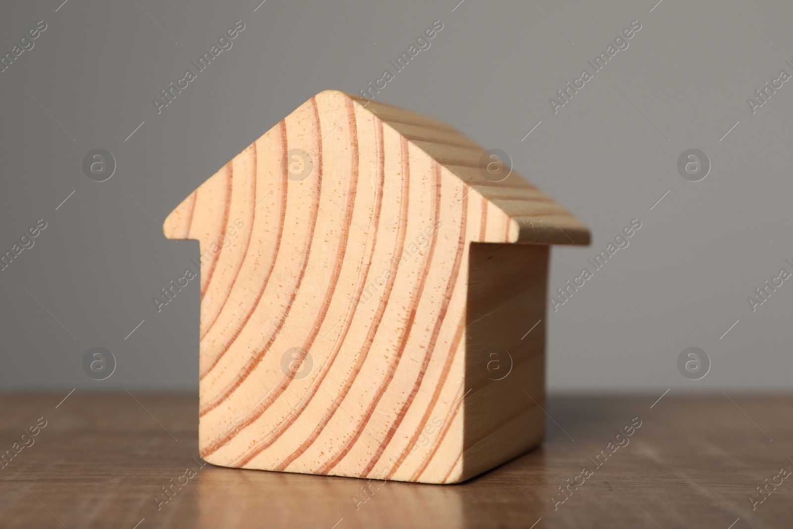 Photo of Mortgage concept. House model on wooden table against grey background