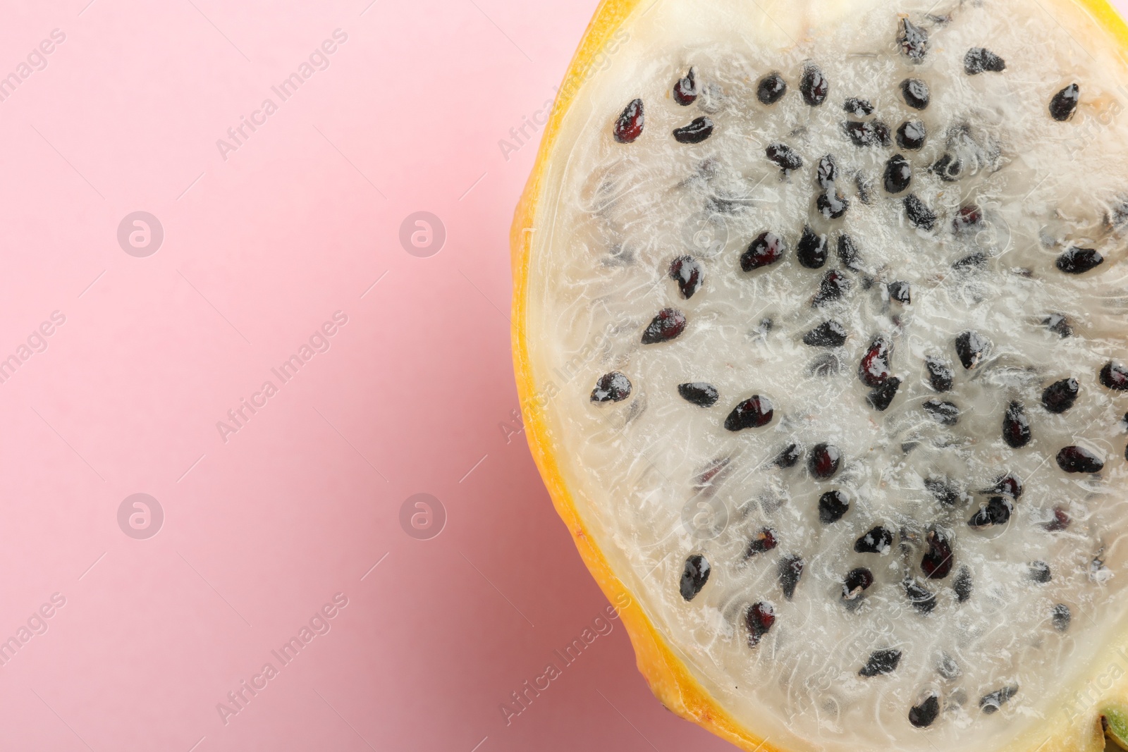 Photo of Delicious cut dragon fruit (pitahaya) on pink background, closeup. Space for text