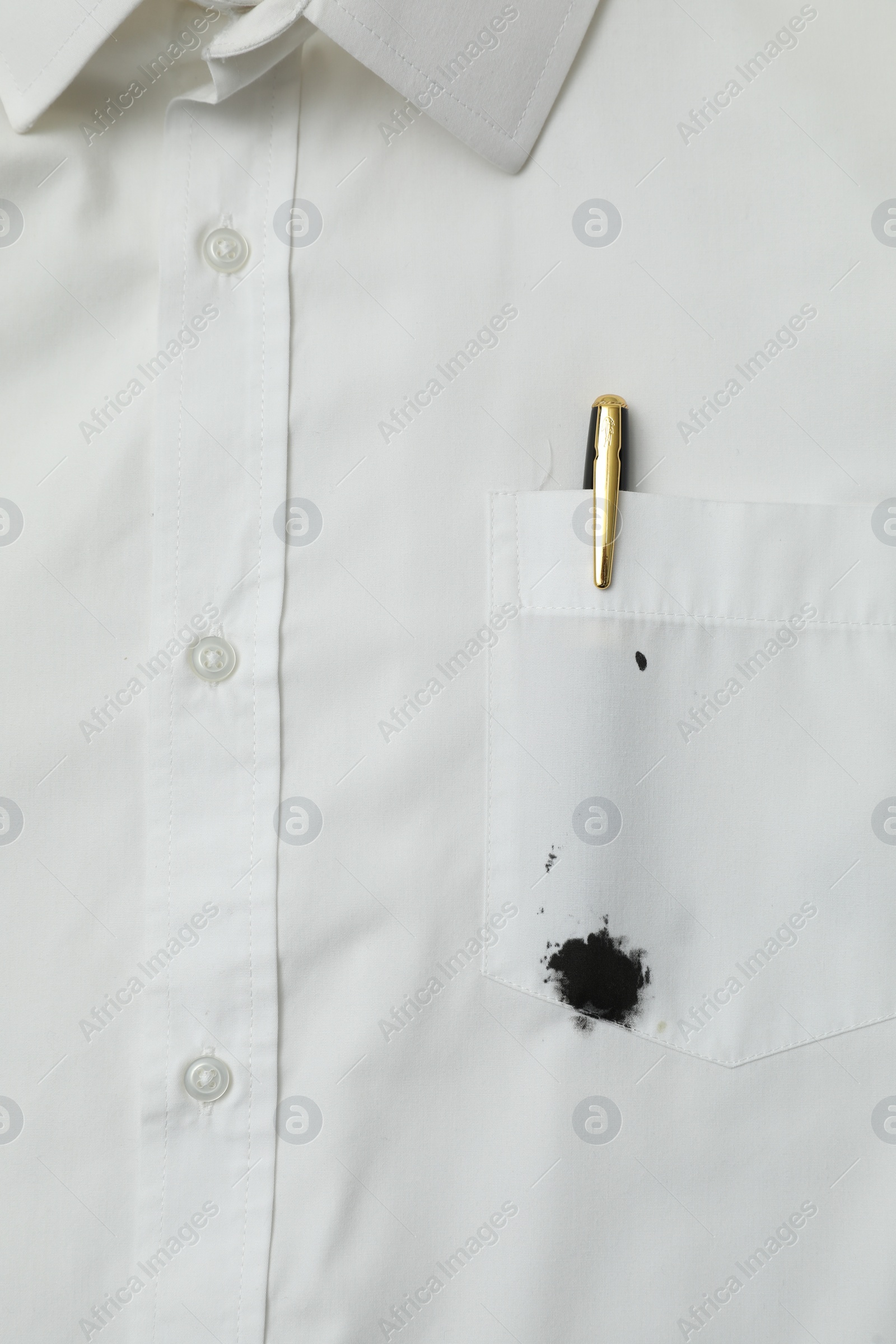 Photo of White shirt with stain of black ink and pen in pocket, top view