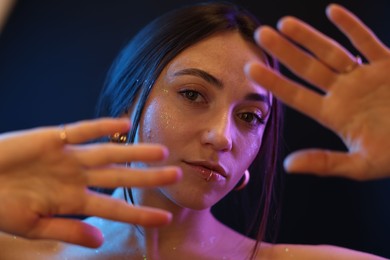 Photo of Portrait of beautiful woman on dark background in neon lights