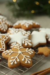 Tasty Christmas cookies with icing and cinnamon sticks on light table, closeup