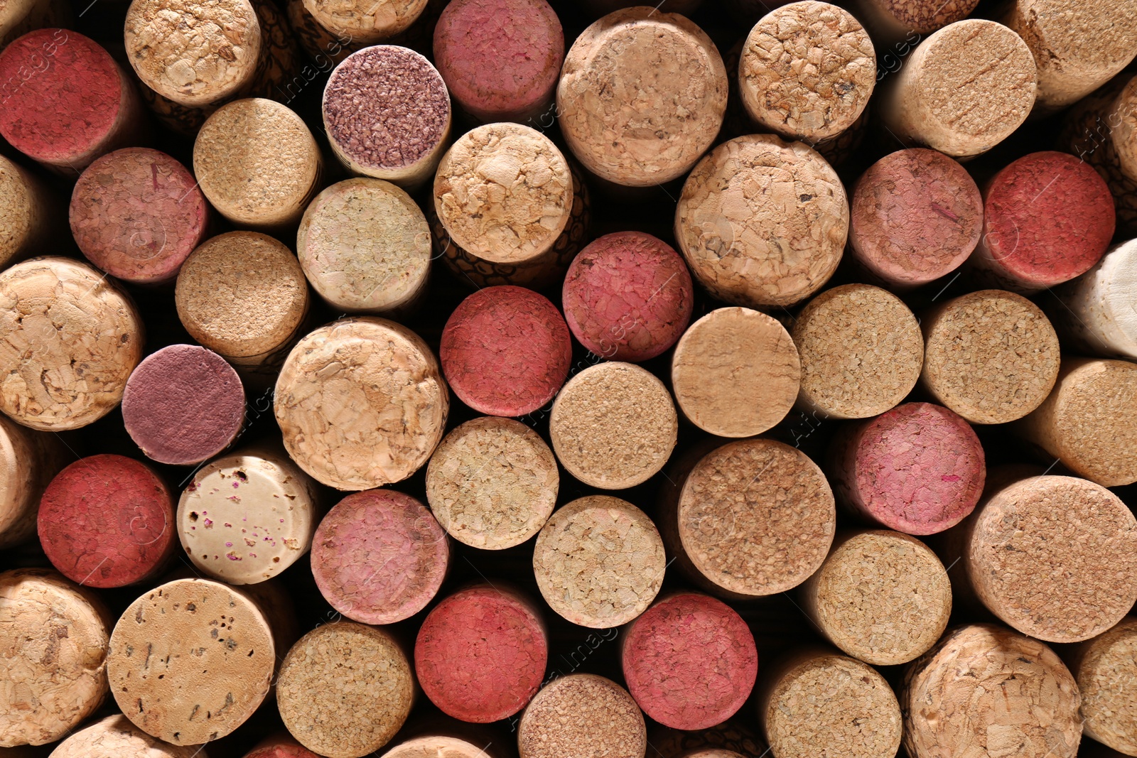 Photo of Many corks of wine bottles as background, top view