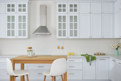 Photo of Stylish wooden table in beautiful kitchen interior