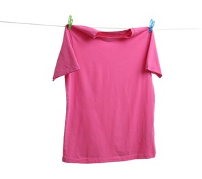 Pink t-shirt drying on washing line against white background