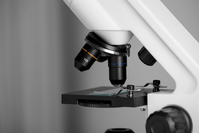 Photo of Modern microscope on grey background, closeup. Medical equipment