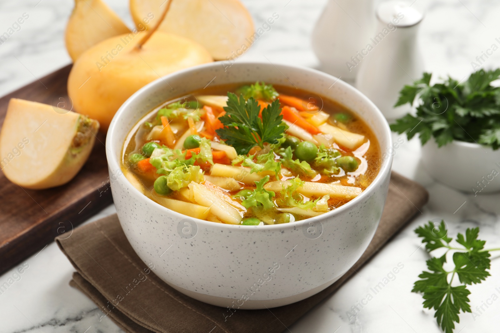 Photo of Bowl of delicious turnip soup on white marble table