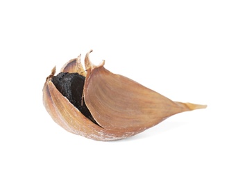 Unpeeled clove of aged black garlic on white background