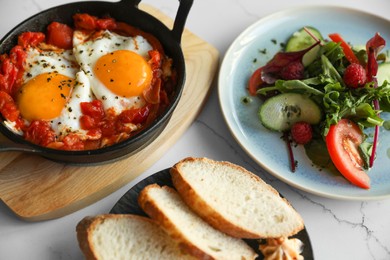 Photo of Tasty Shakshouka served on white table. Traditional Arabic dish