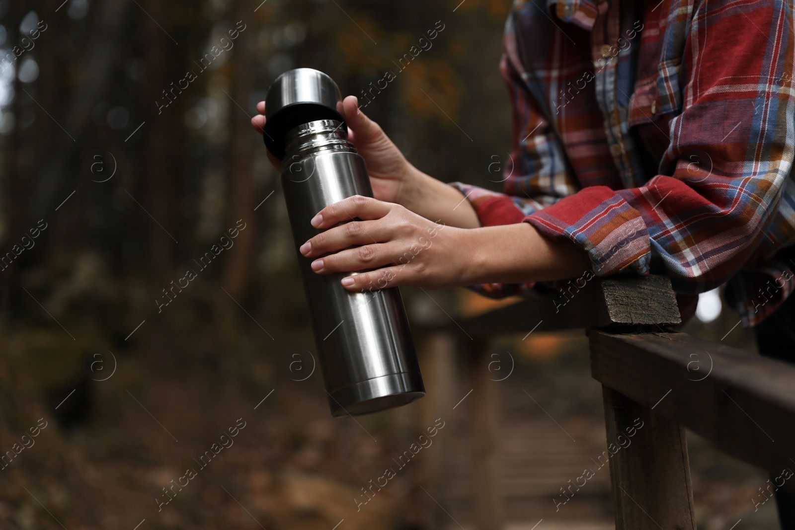 Photo of Woman with metallic thermos in nature, closeup