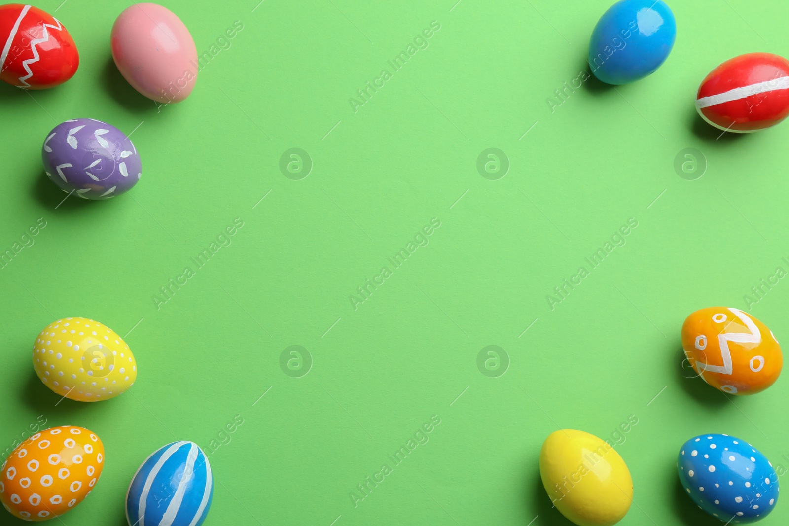 Photo of Flat lay composition of painted Easter eggs on color background, space for text