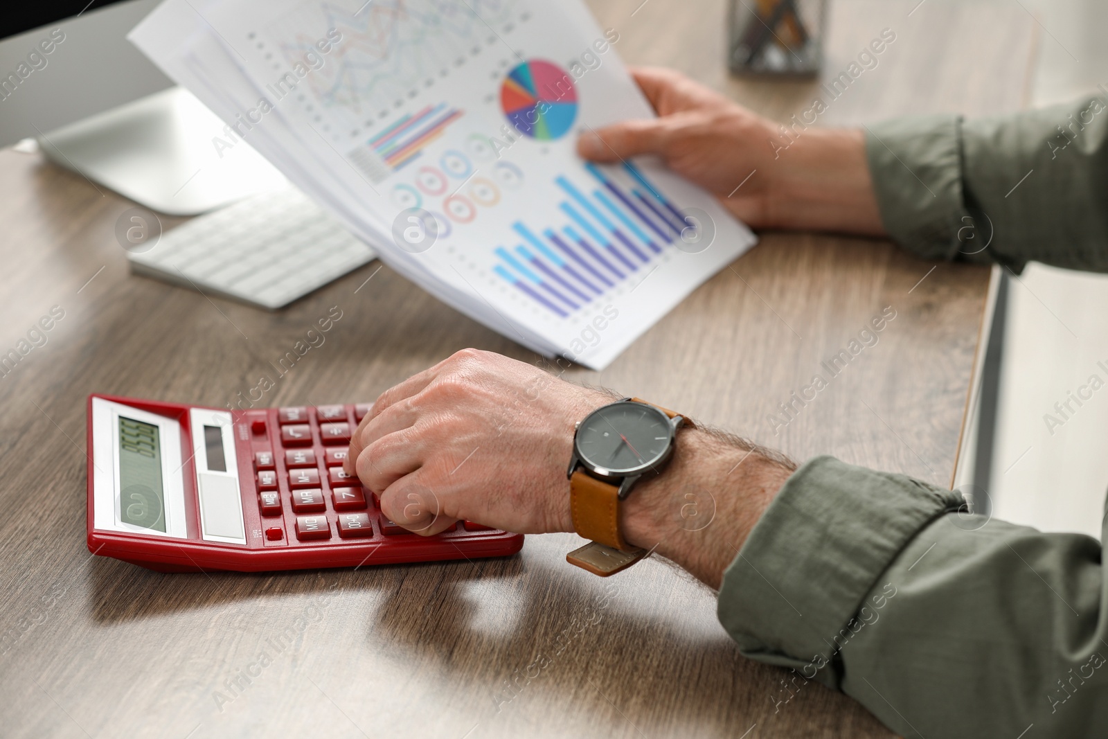 Photo of Professional accountant using calculator at wooden desk, closeup