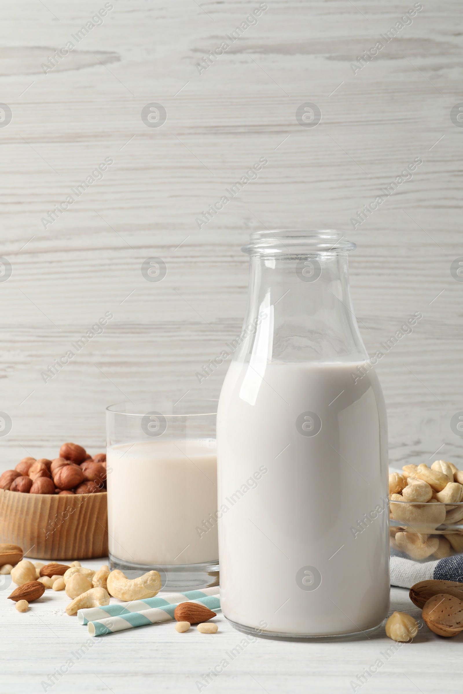 Photo of Different nut milks on white wooden table