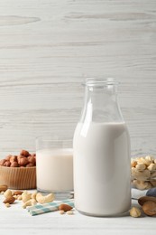 Different nut milks on white wooden table