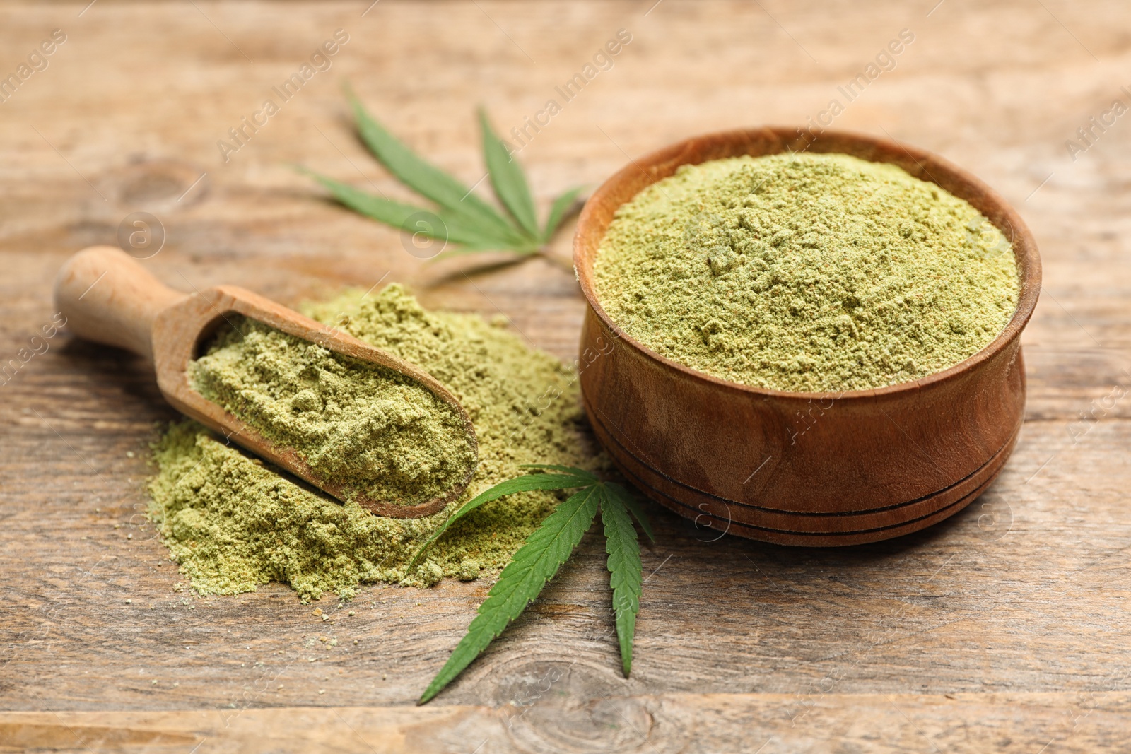 Photo of Bowl and scoop of hemp protein powder on wooden table