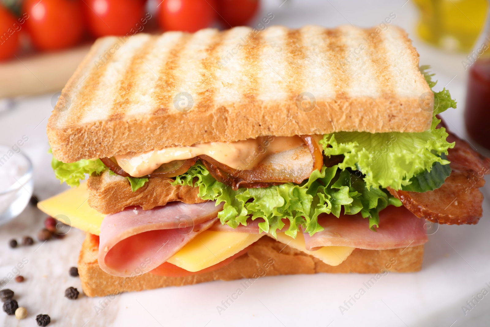 Photo of Tasty sandwich with ham and bacon served on table, closeup