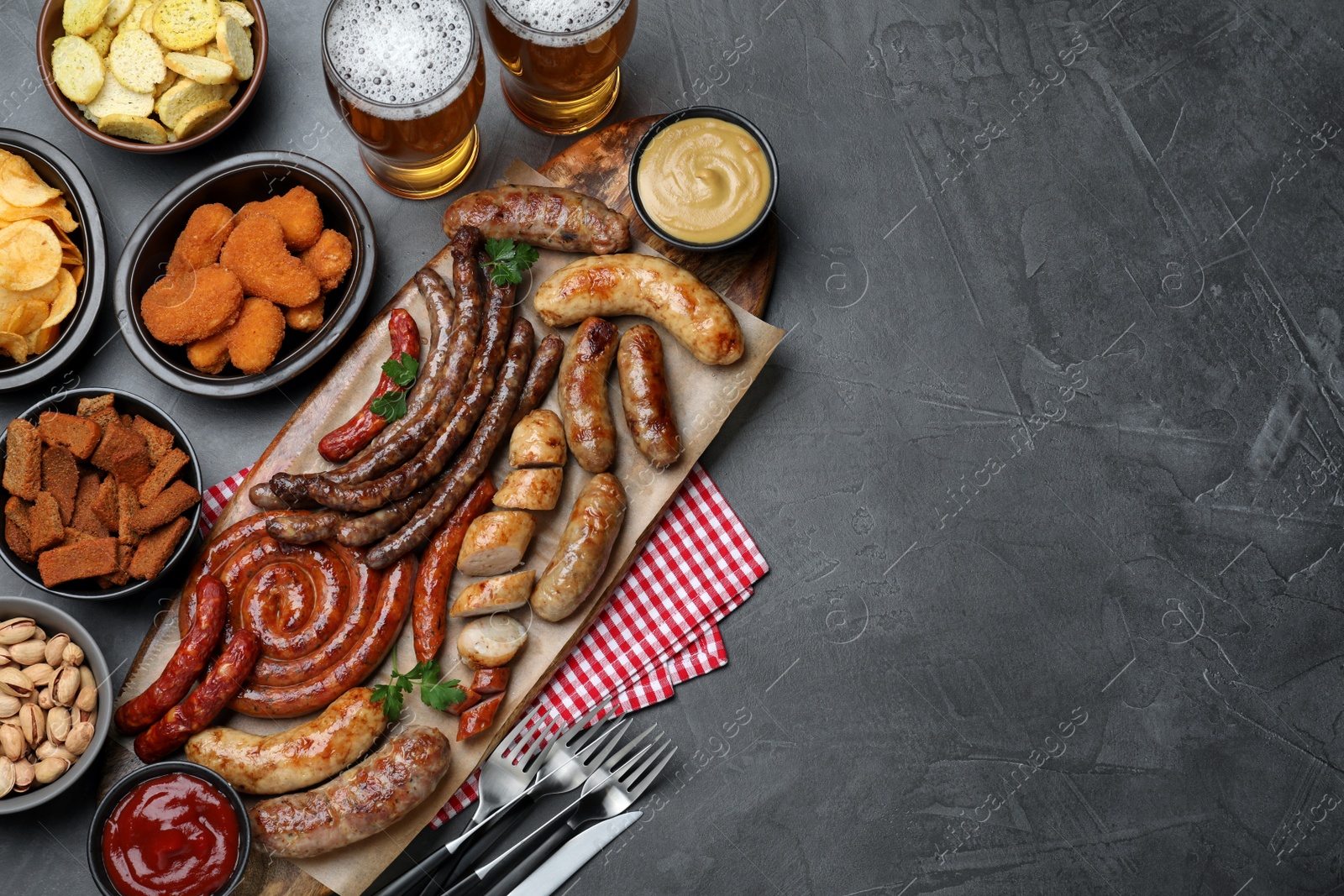 Photo of Set of different tasty snacks and beer on dark grey table, flat lay. Space for text