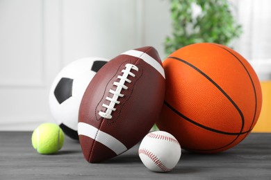 Set of different sport balls on grey wooden table indoors