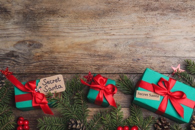 Flat lay composition with presents from secret Santa on wooden table, space for text