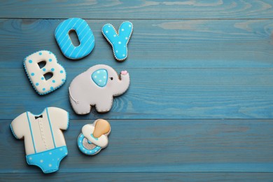 Photo of Word Boy, tasty cookies and space for text on light blue wooden table, flat lay. Baby shower party