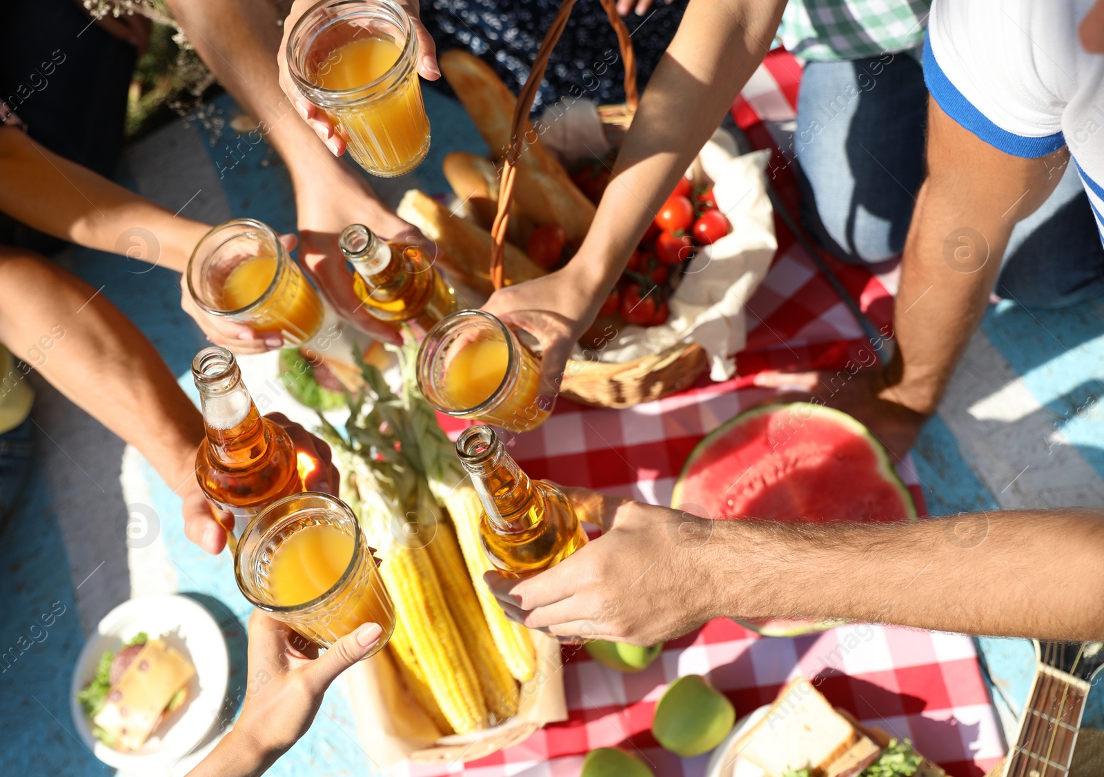 Photo of Young people enjoying picnic in park on summer day, top view