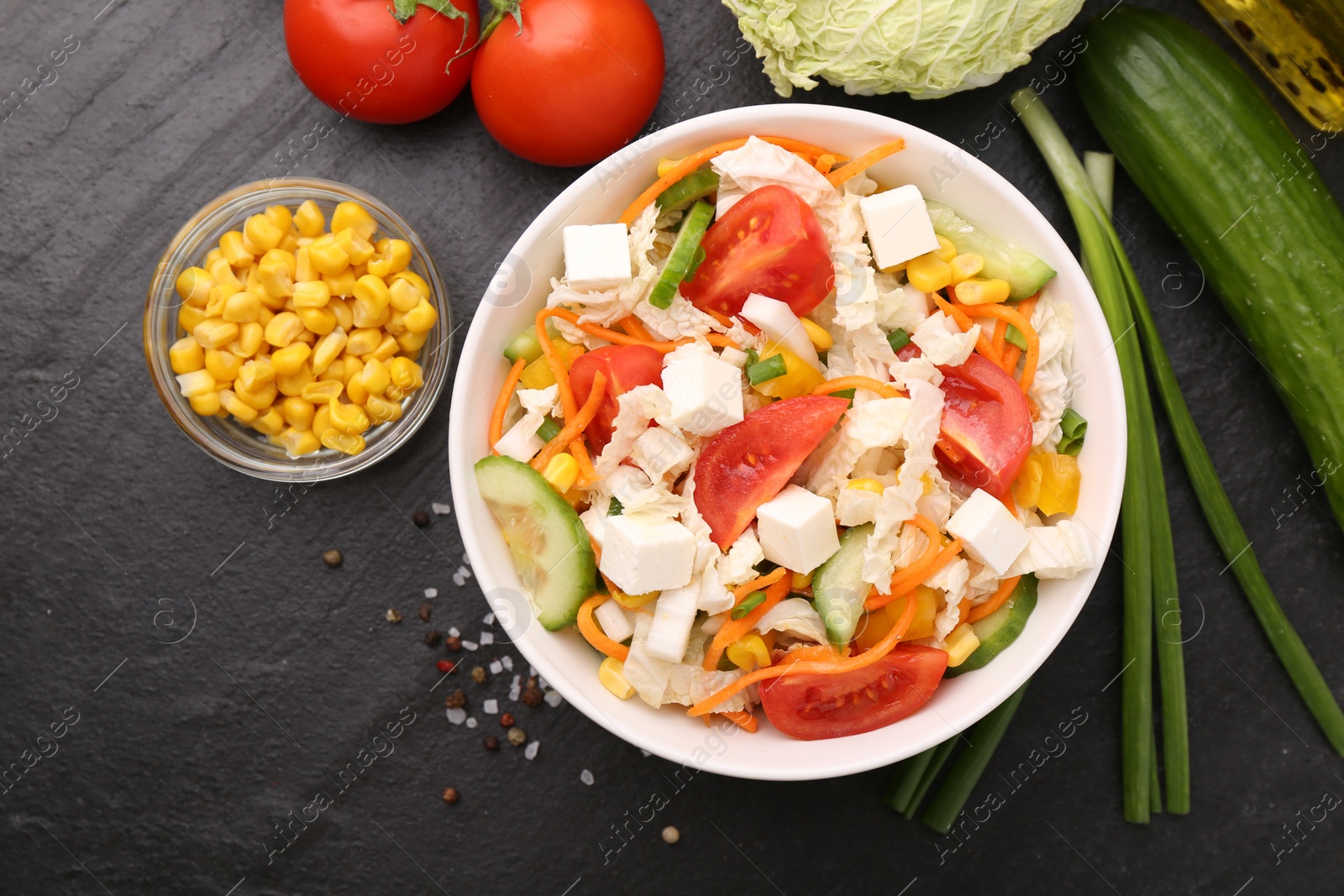 Photo of Tasty salad with Chinese cabbage served on black table, flat lay