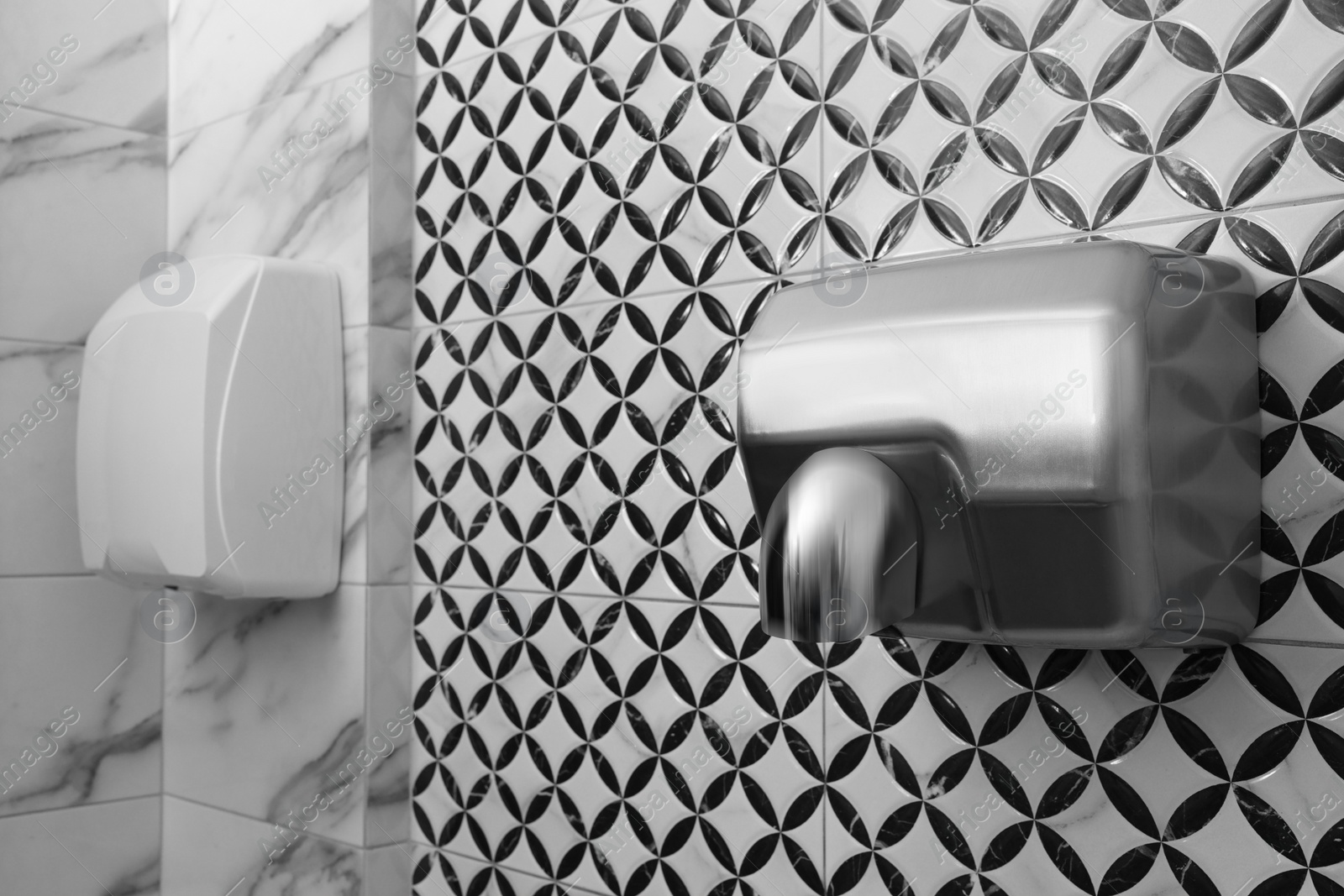 Photo of Hot air hand dryer on wall in public toilet