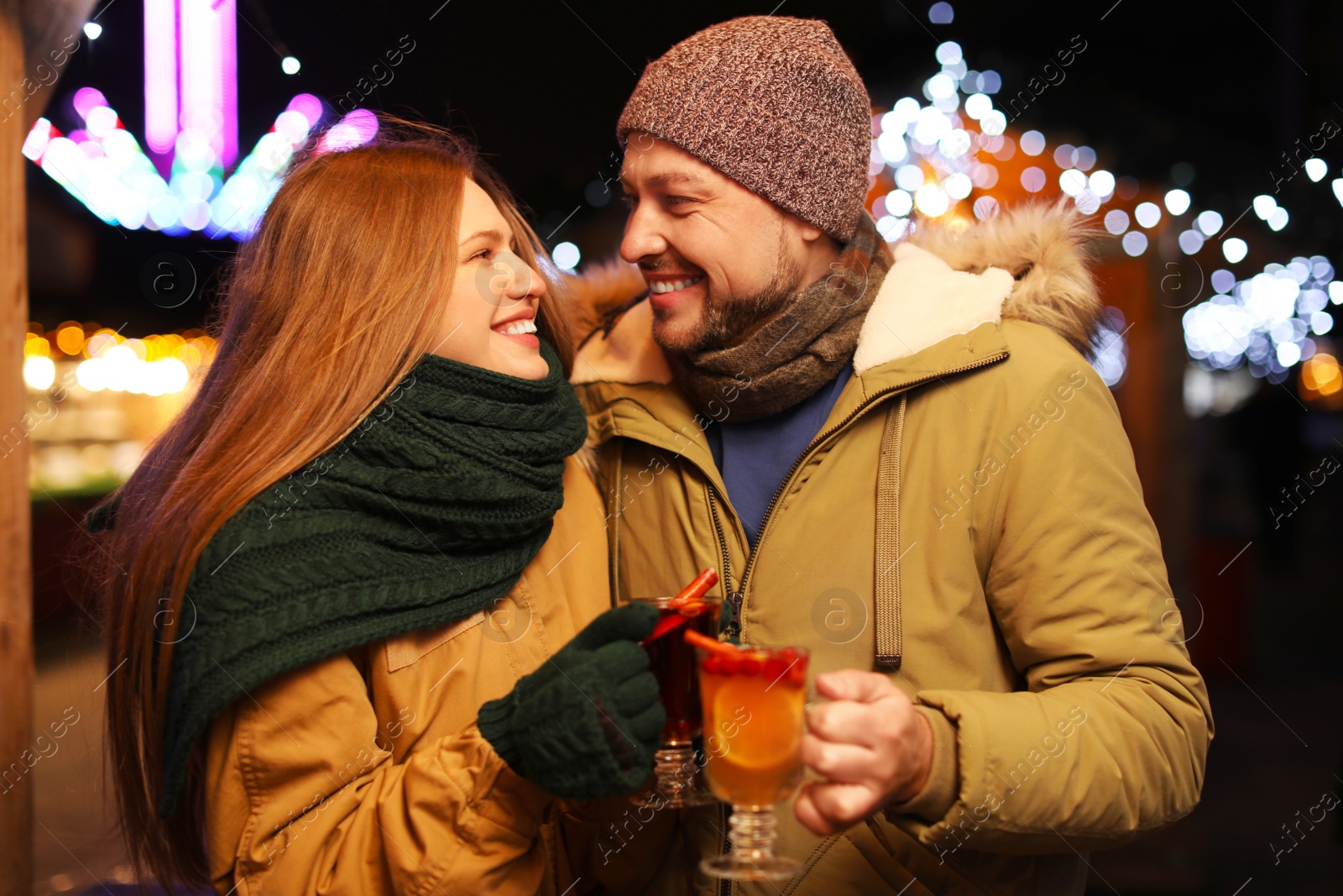 Photo of Happy couple with mulled wine at winter fair