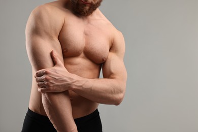 Man with muscular body on light grey background, closeup. Space for text