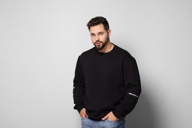Handsome man in stylish sweater on white background