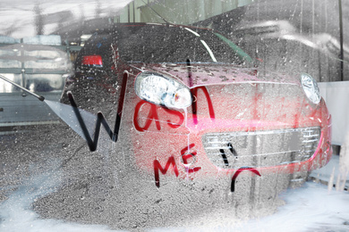 Image of Text Wash Me and cleaning car with high pressure water jet