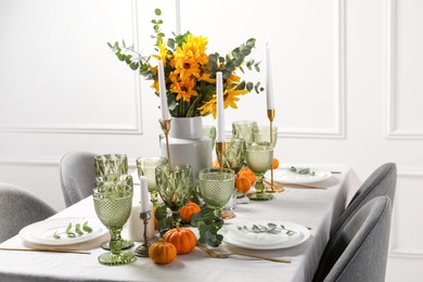 Photo of Beautiful autumn table setting with bouquet indoors. Plates, cutlery, glasses and floral decor