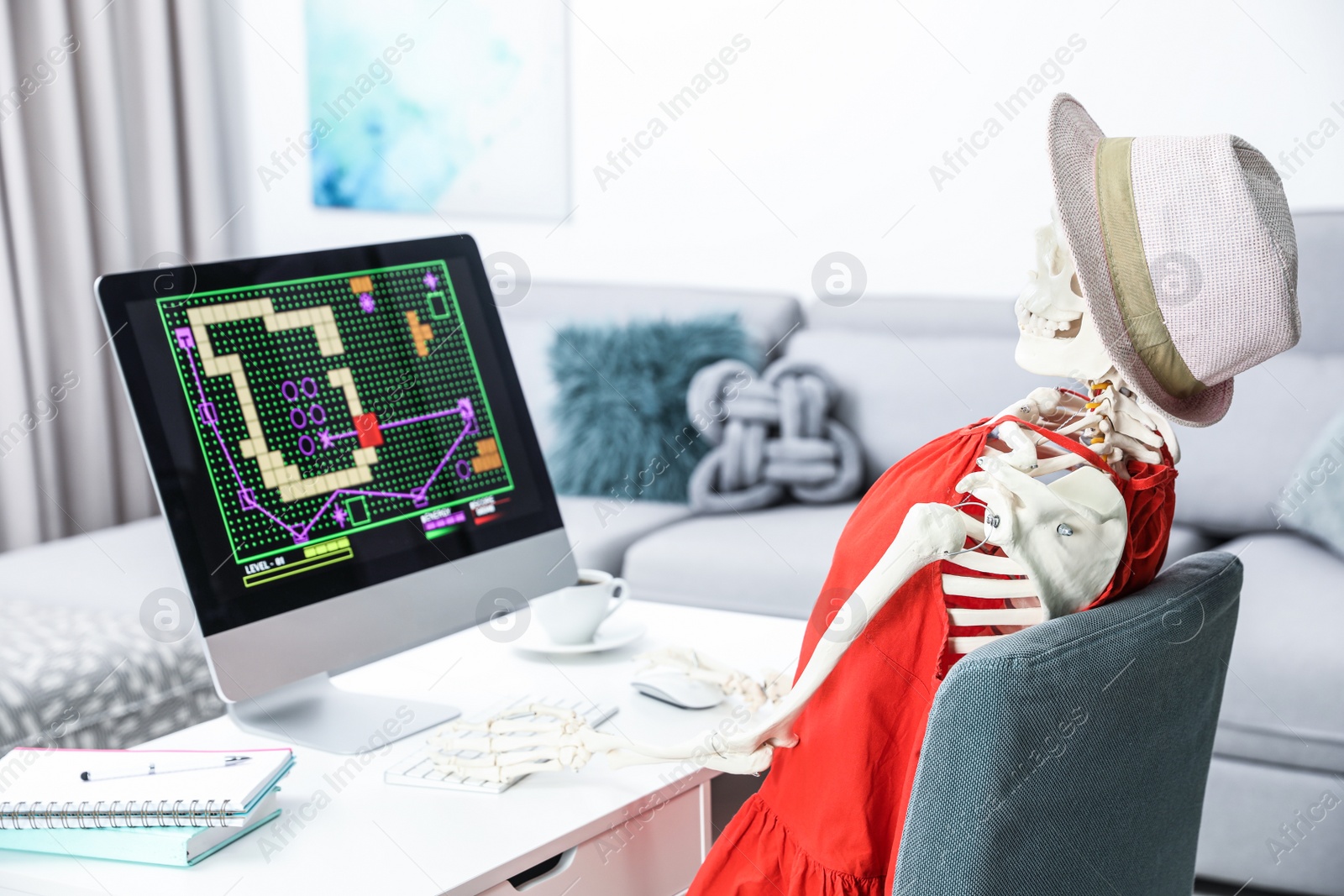Photo of Human skeleton playing game at table indoors