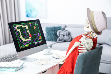 Human skeleton playing game at table indoors