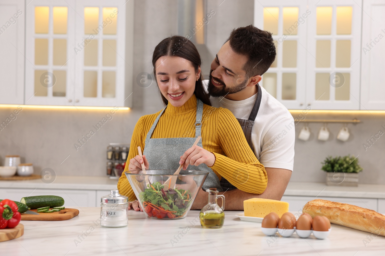 Photo of Lovely young couple cooking together in kitchen