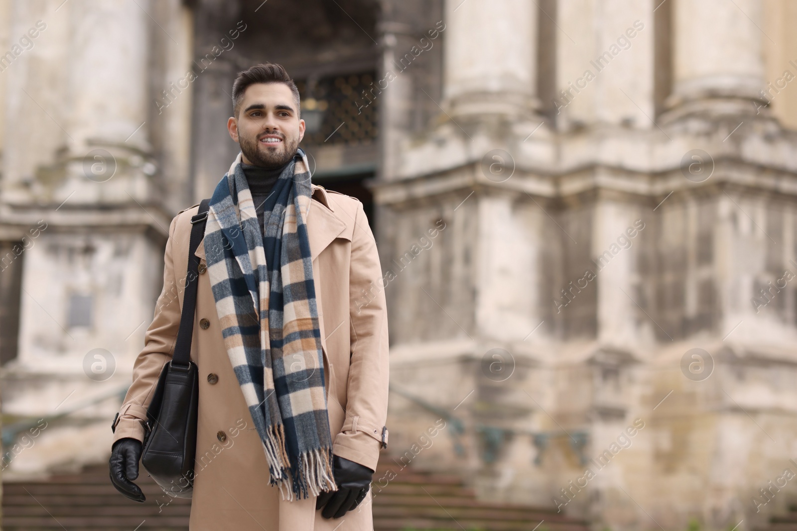 Photo of Smiling man in warm scarf outdoors. Space for text