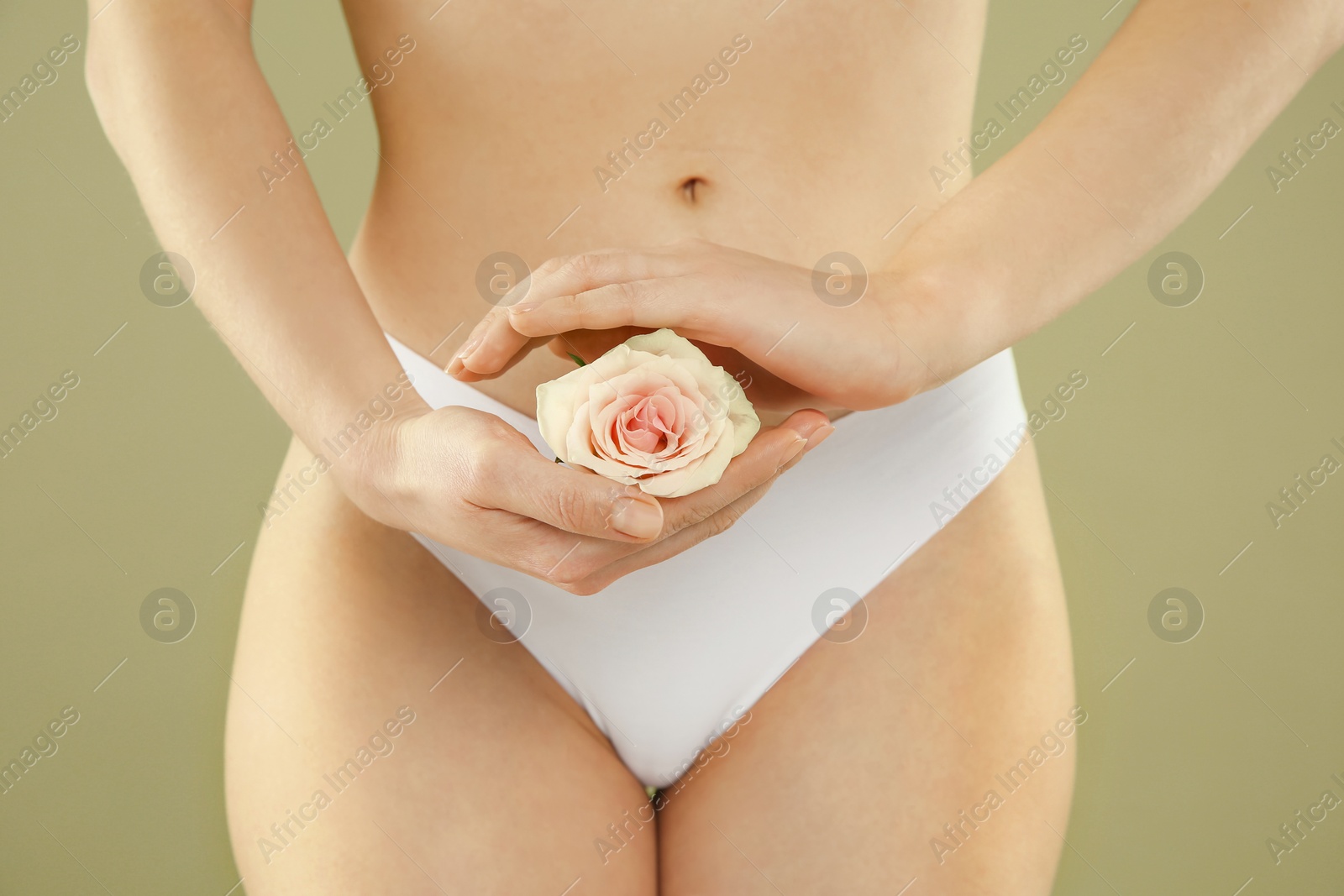 Photo of Gynecology. Woman in underwear with rose flower on green background, closeup