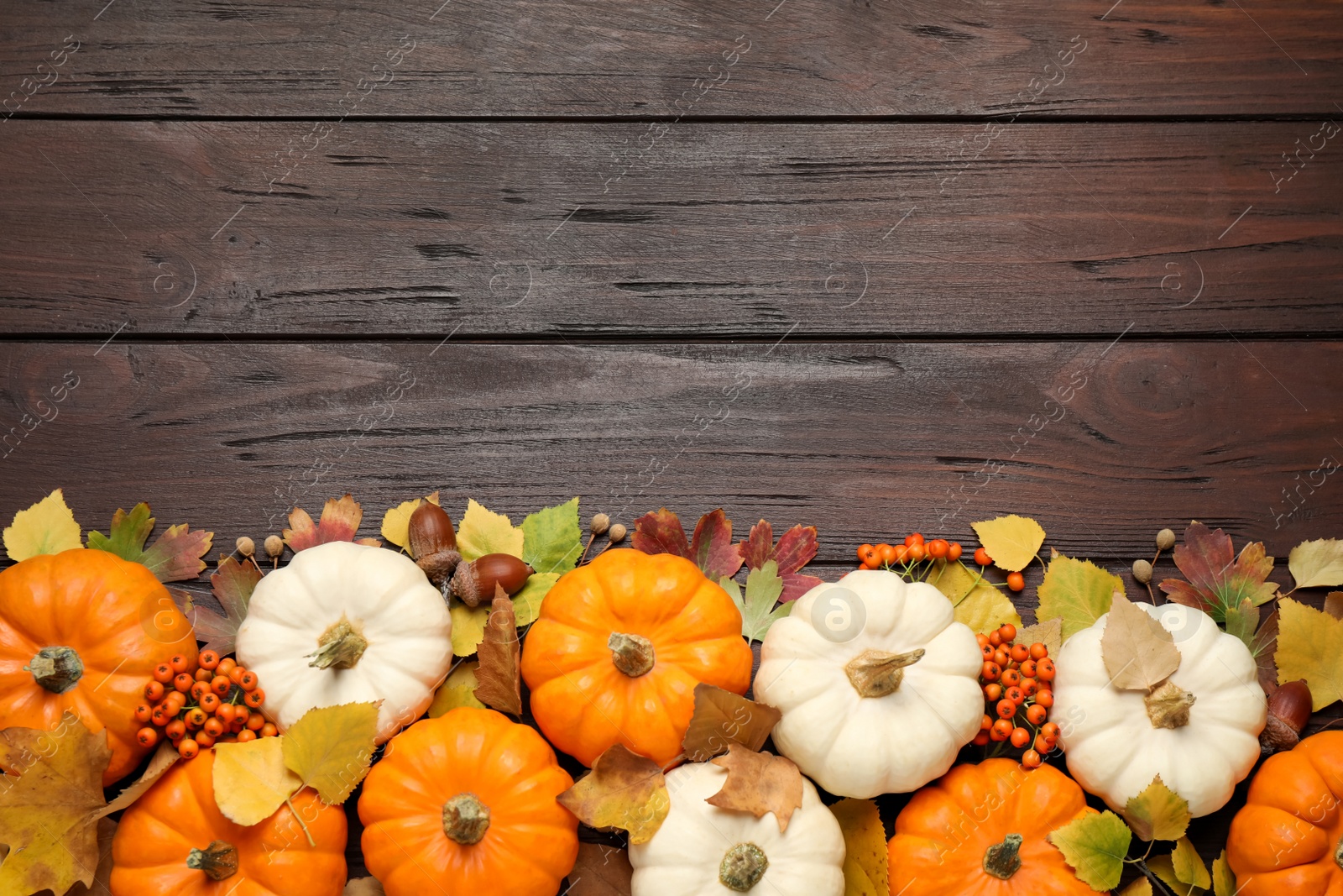 Photo of Flat lay composition with pumpkins and autumn leaves on wooden table. Space for text