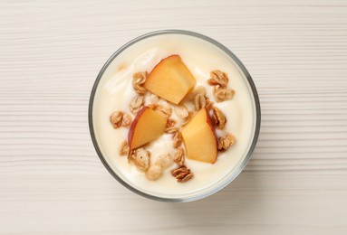 Photo of Delicious yogurt with fresh peach and granola on white wooden table, top view