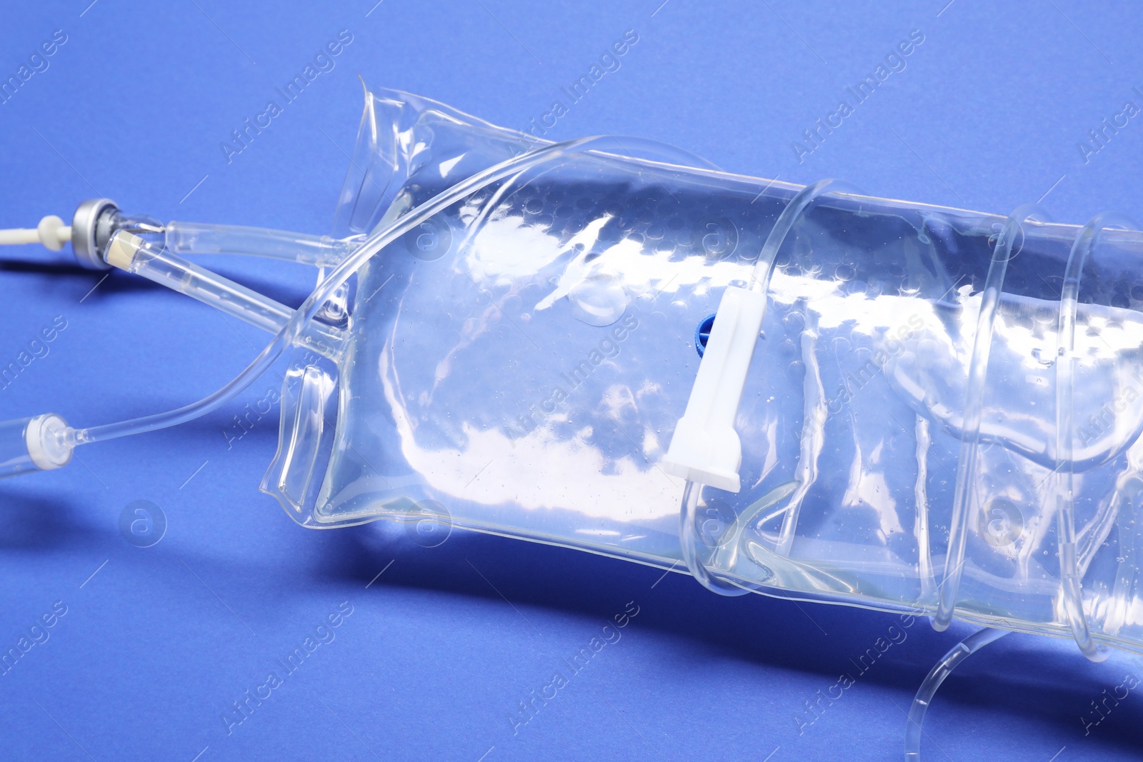 Photo of IV infusion set on blue background, closeup