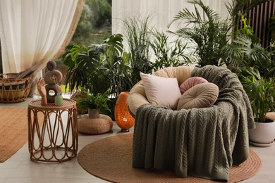 Photo of Indoor terrace interior with soft papasan chair and green plants