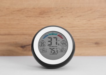 Photo of Digital hygrometer with thermometer on white table