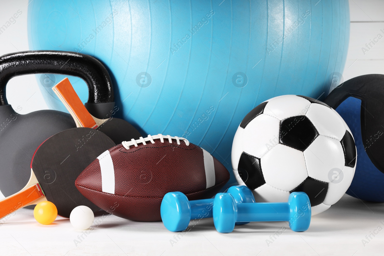 Photo of Many different sports equipment on white table