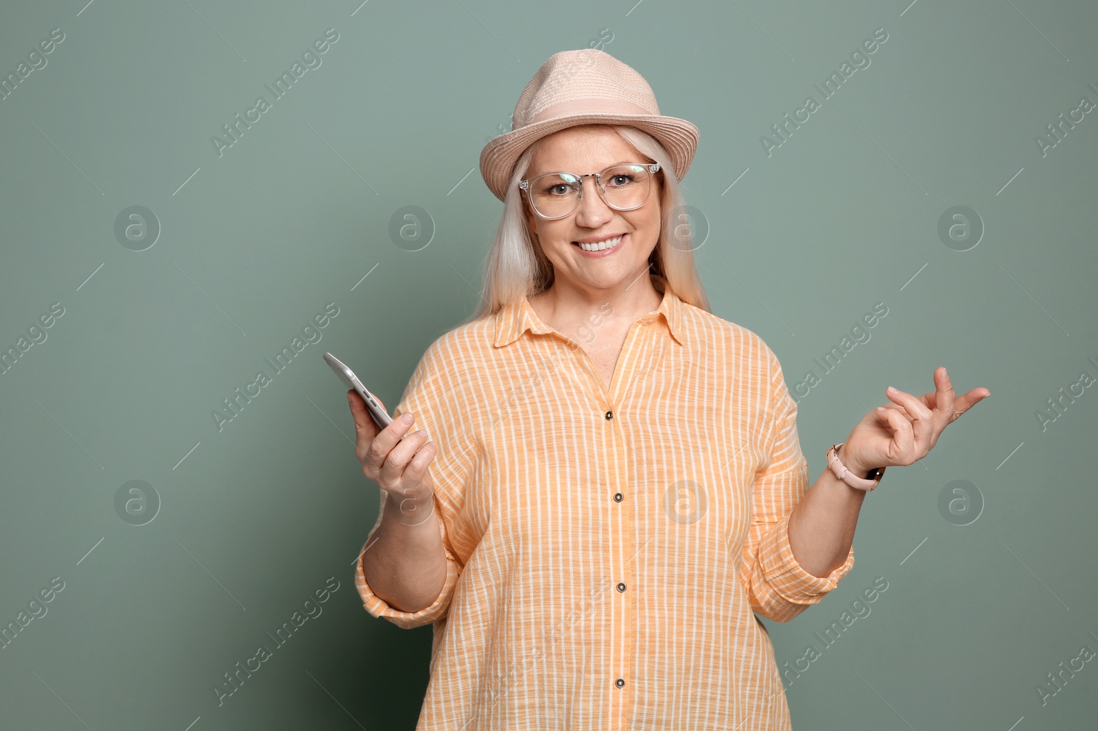 Photo of Mature woman with mobile phone on color background