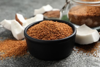 Natural coconut sugar in bowl on grey table