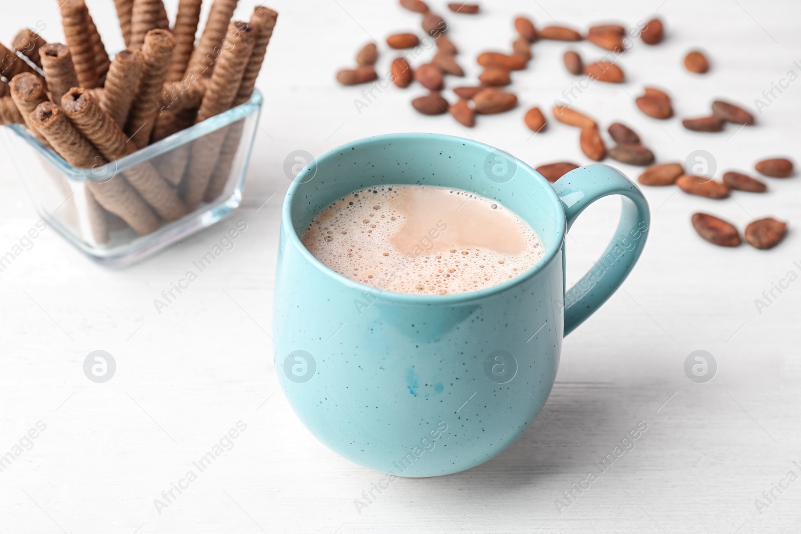Photo of Mug with delicious hot cocoa drink and cookies on table