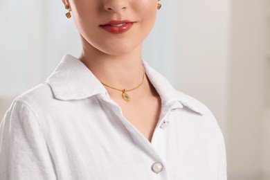 Beautiful woman with elegant jewelry on light background, closeup