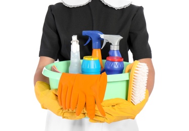 Photo of Young chambermaid holding plastic basin with detergents on white background