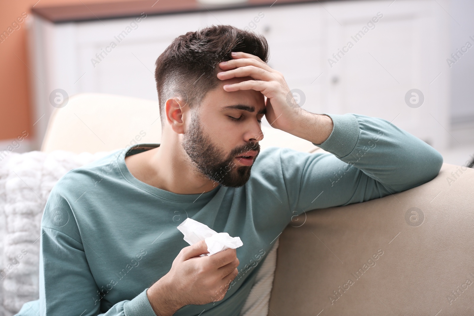 Photo of Man suffering from runny nose at home