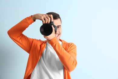 Photo of Male photographer with camera on light background